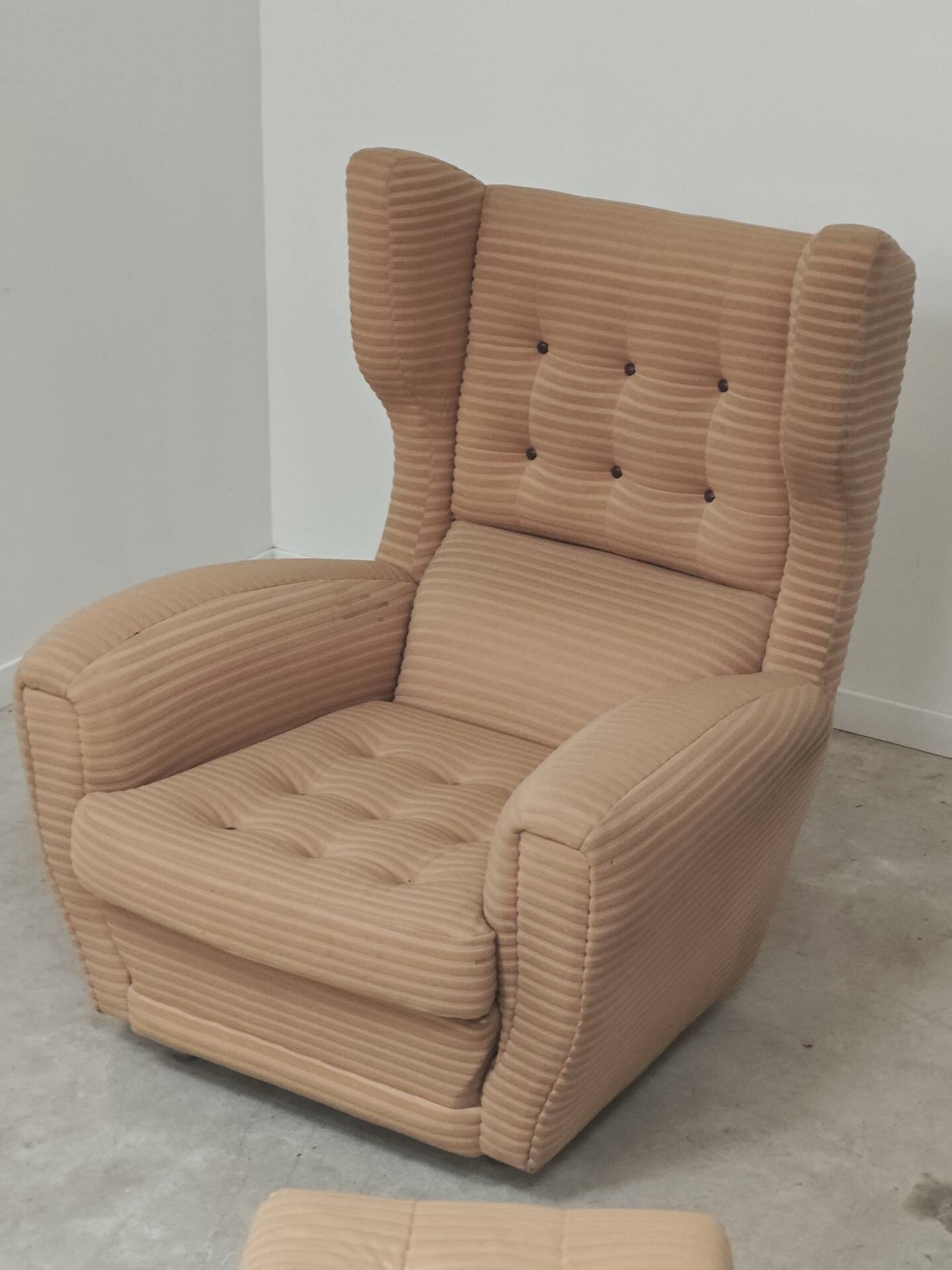 Beige wingback armchair and TVAR footrest, former Czechoslovakia.