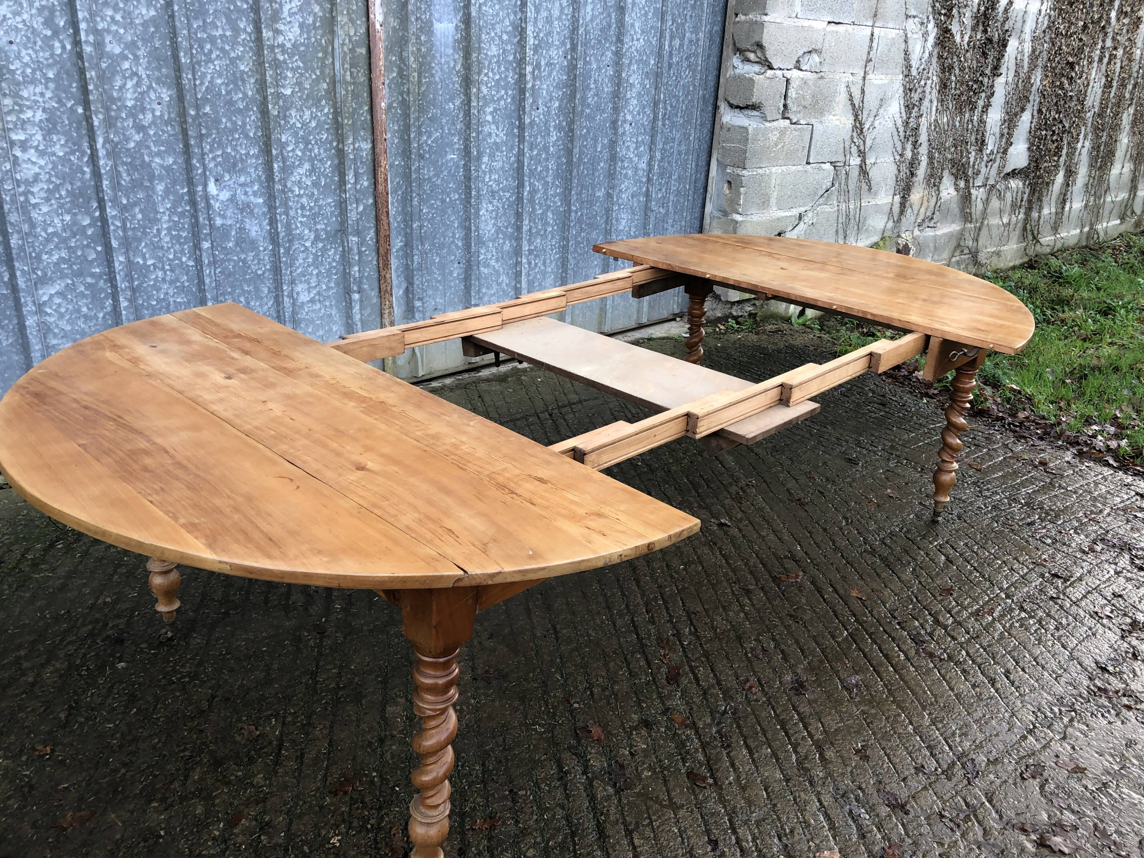 Round table in solid cherry wood, extendable with twisted legs, Louis Philippe style.