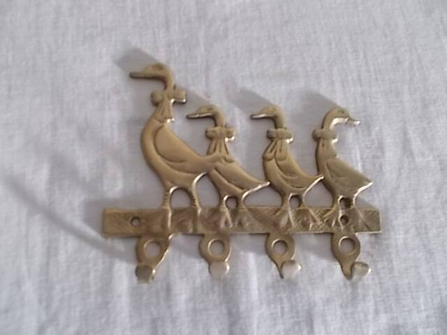 Wall-mounted tea towel holder or key holder in brass with ducks.