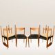 Set of 6 modernist chairs with black faux leather seats.