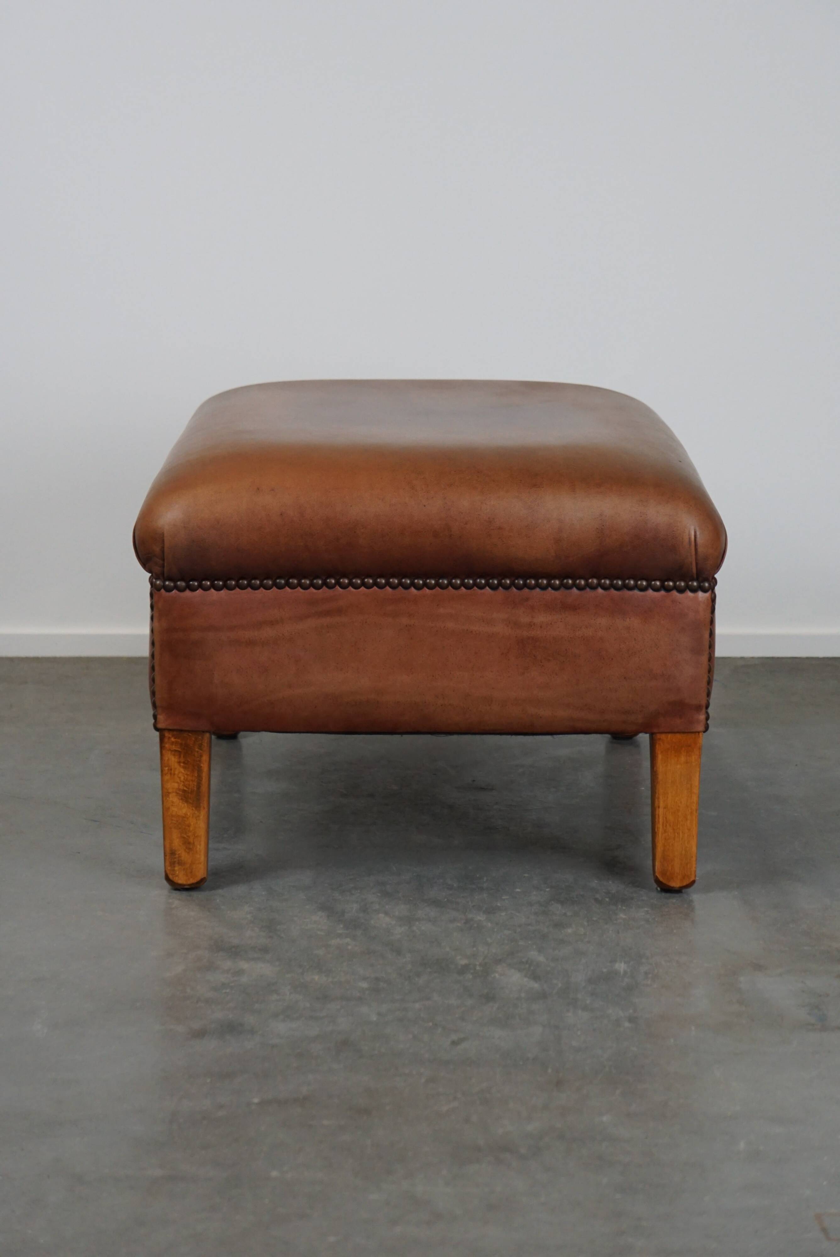 English-style leather ottoman in cognac-colored leather
