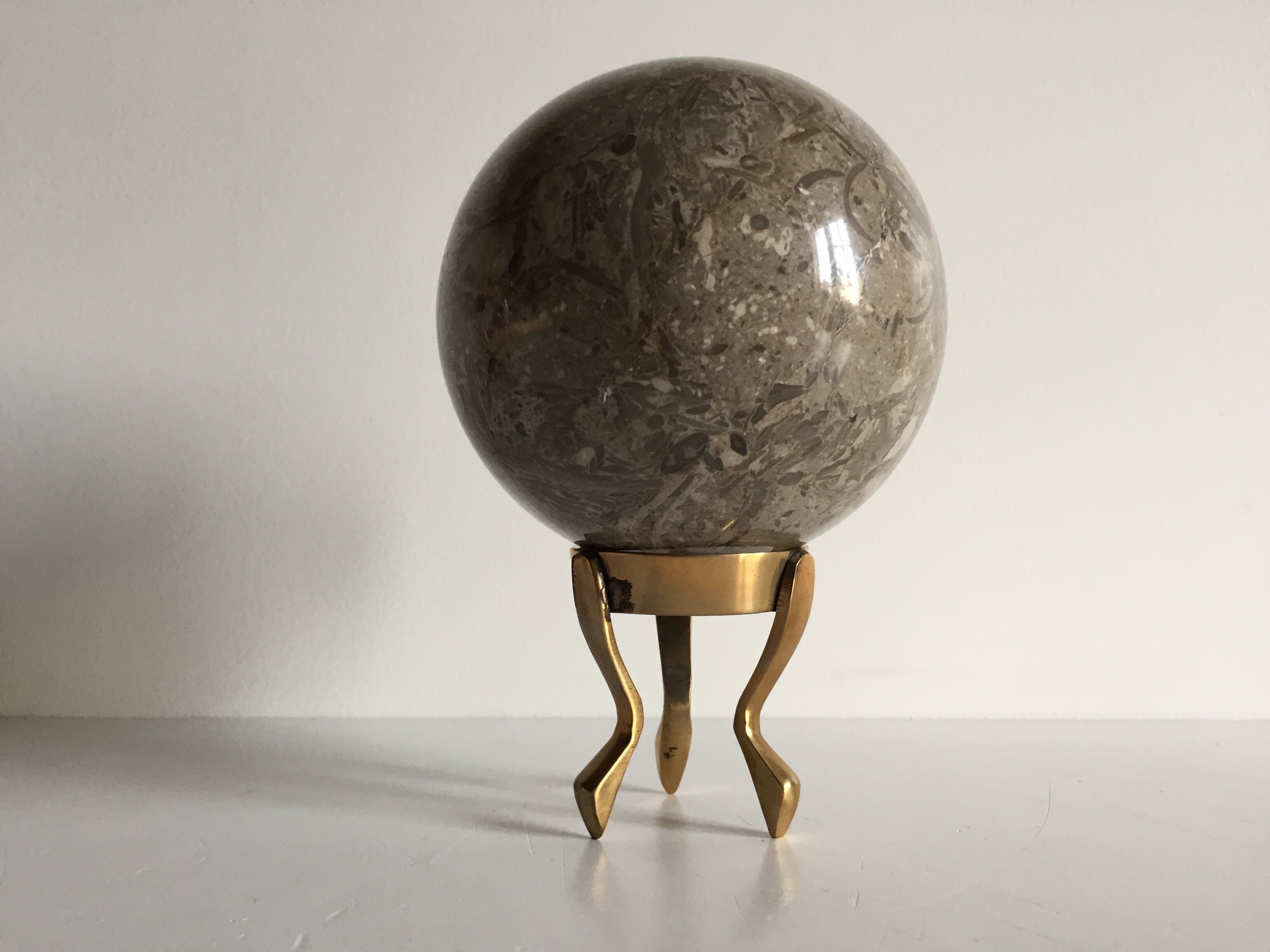 Marble ball paperweight on vintage brass