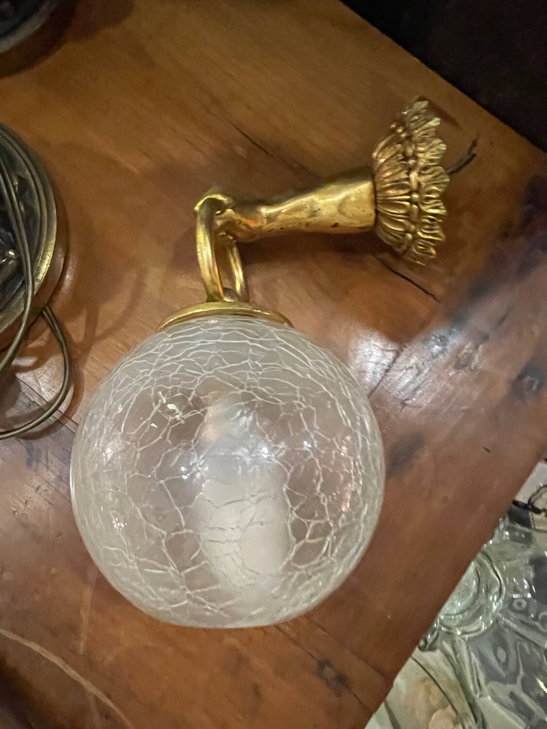 Vintage wall light in gilded bronze with a cracked glass globe.