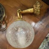 Vintage wall light in gilded bronze with a cracked glass globe.