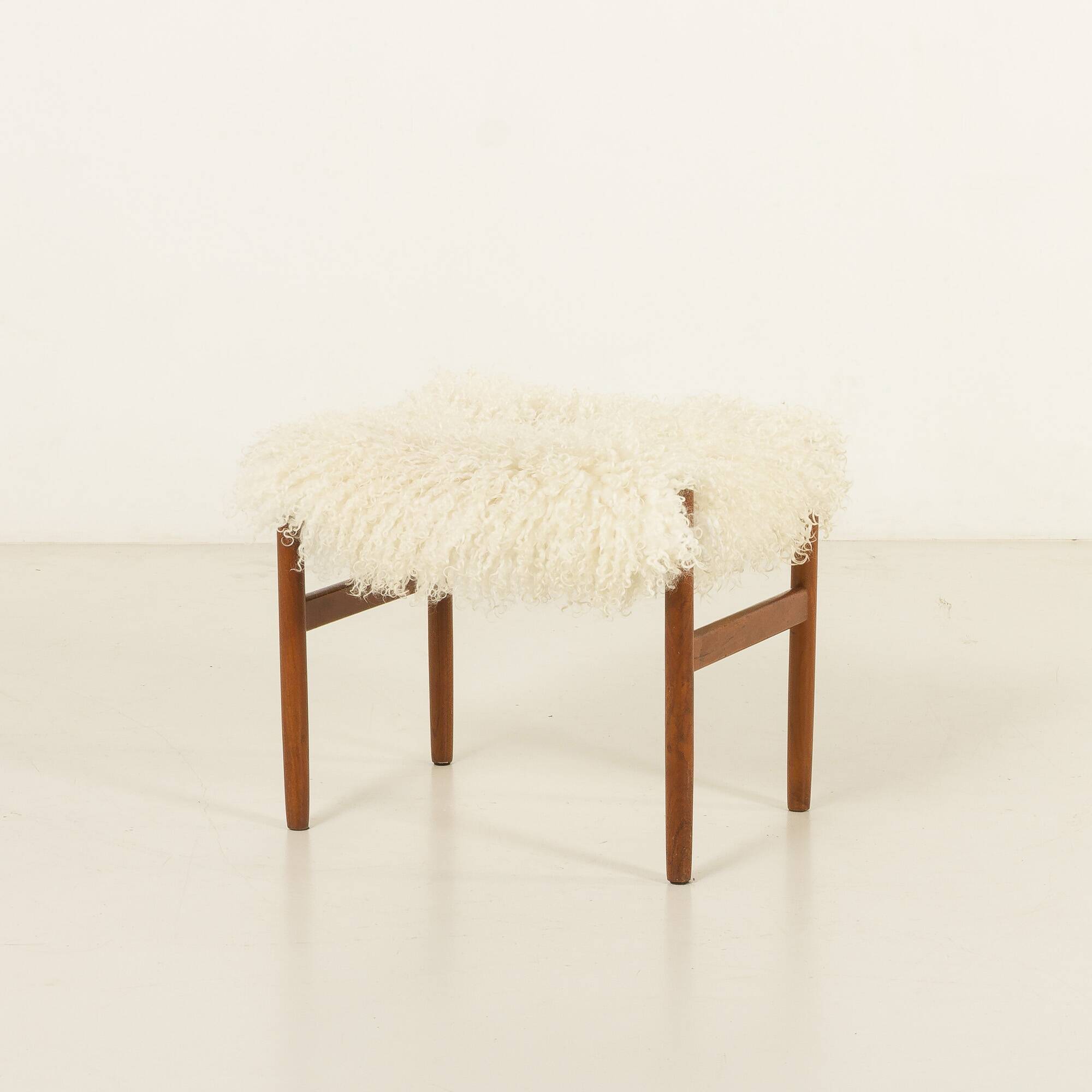 Pouf en teck danois des années 60 recouvert de peau de mouton à poils longs.