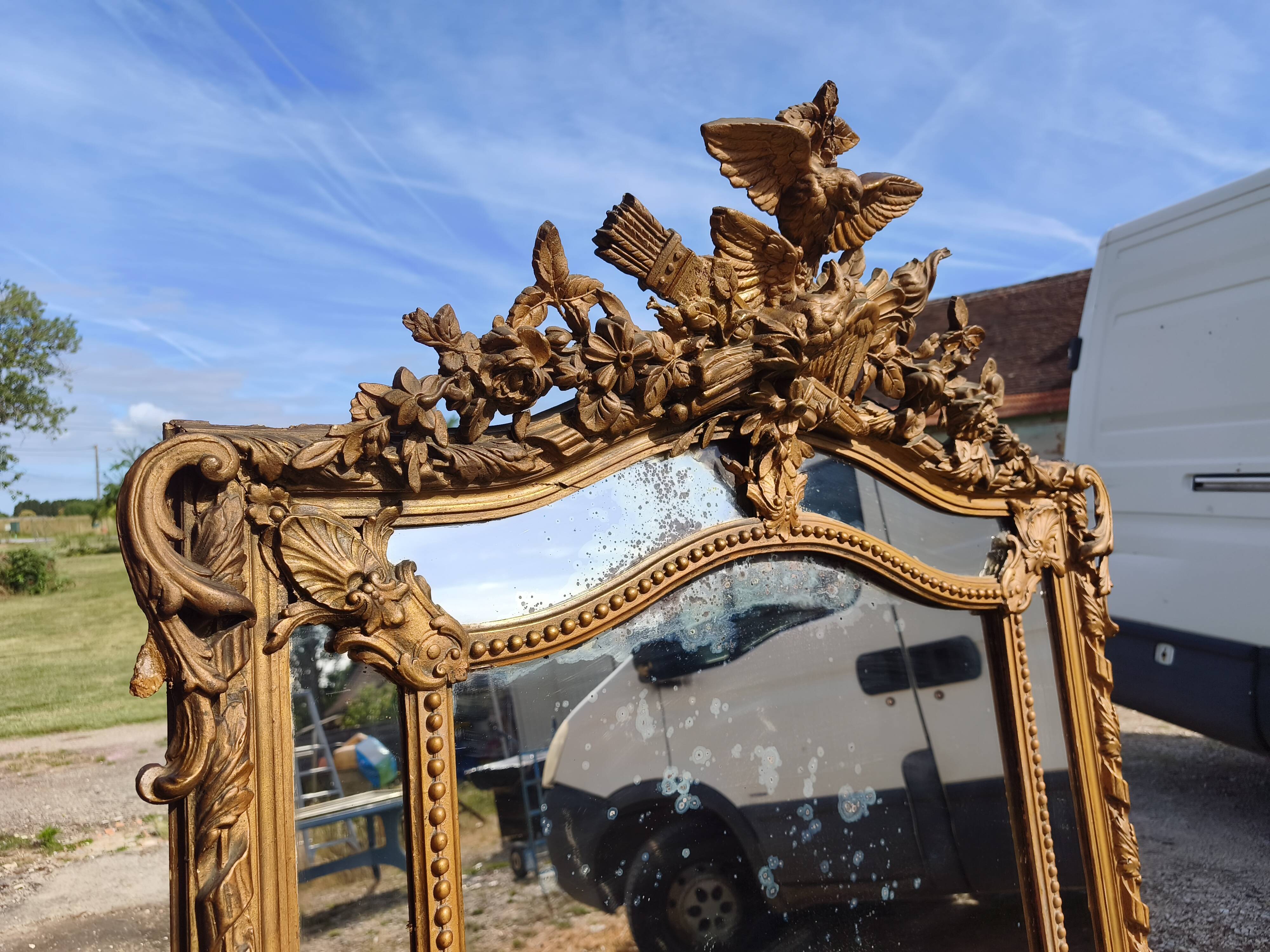 Large closed mirror, 19th century, wood and gilded stucco.