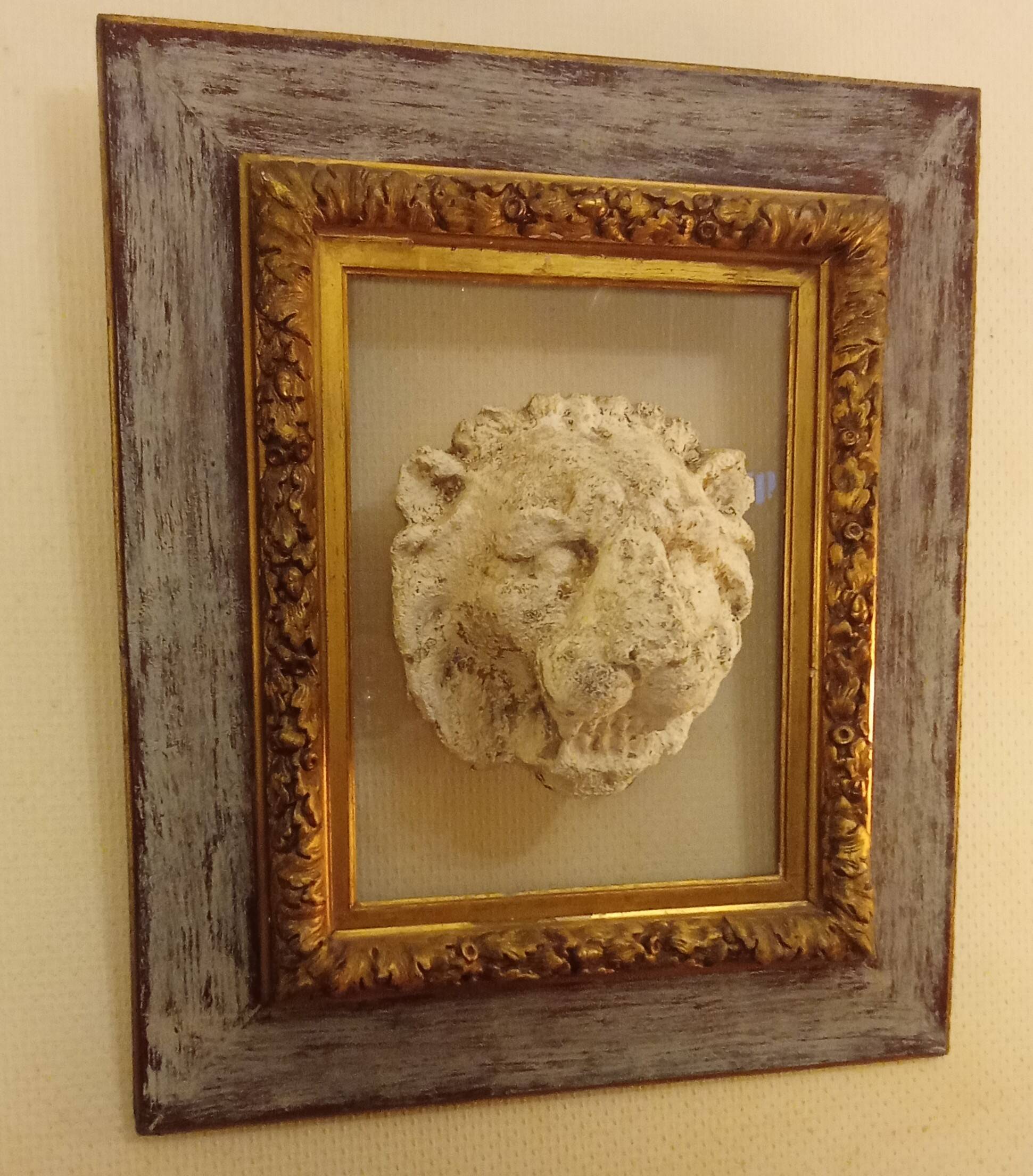 Antique gilded frame with stone lion head ornament on plexiglass