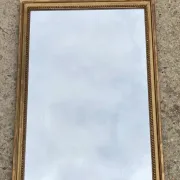 Antique mirror in wood and gilded stucco with a pediment - in the style of the 18th century.