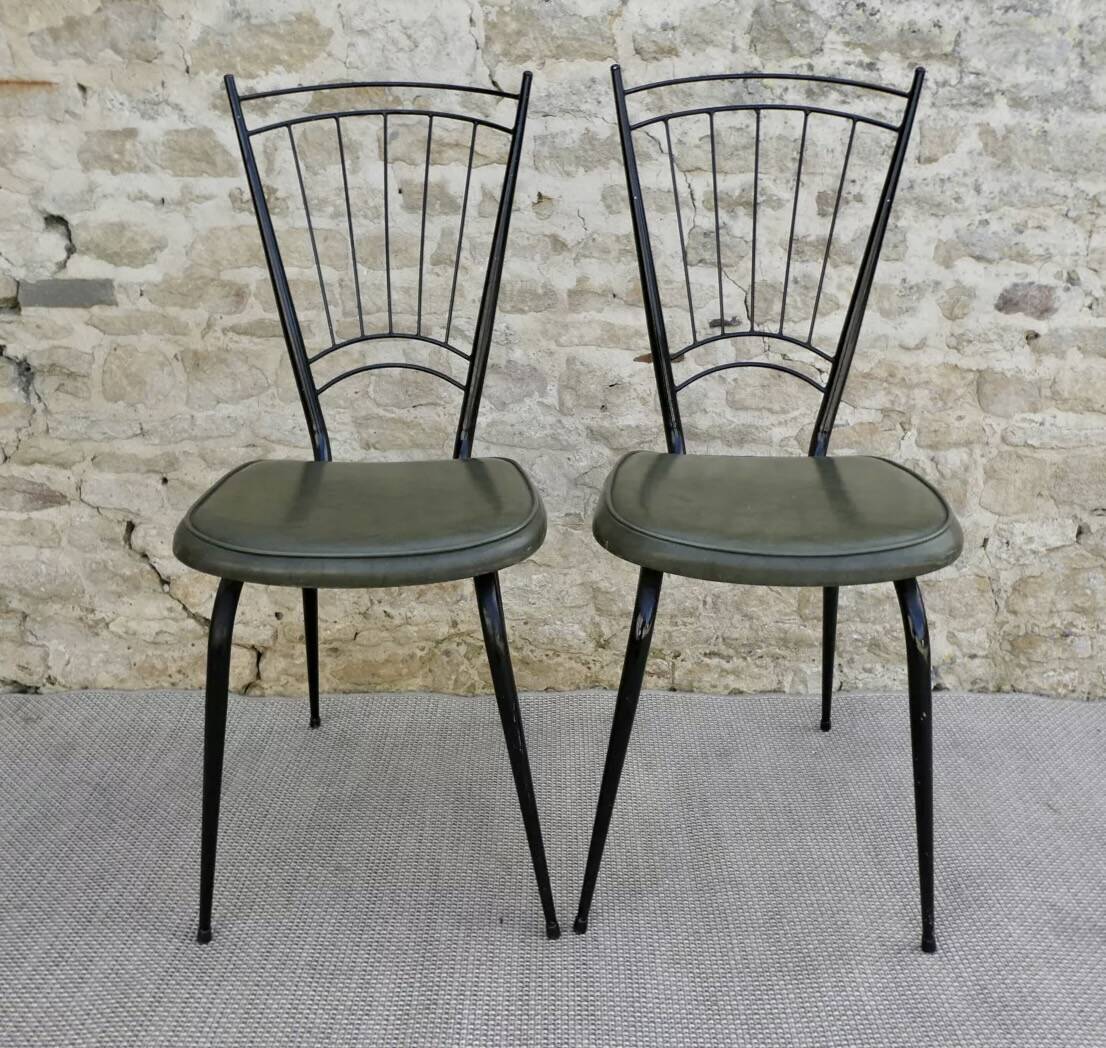 Black metal chairs with khaki faux leather seats, circa 1960.