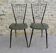 Black metal chairs with khaki faux leather seats, circa 1960.
