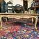 Louis XV style coffee table in carved wood with grey and gold highlights.