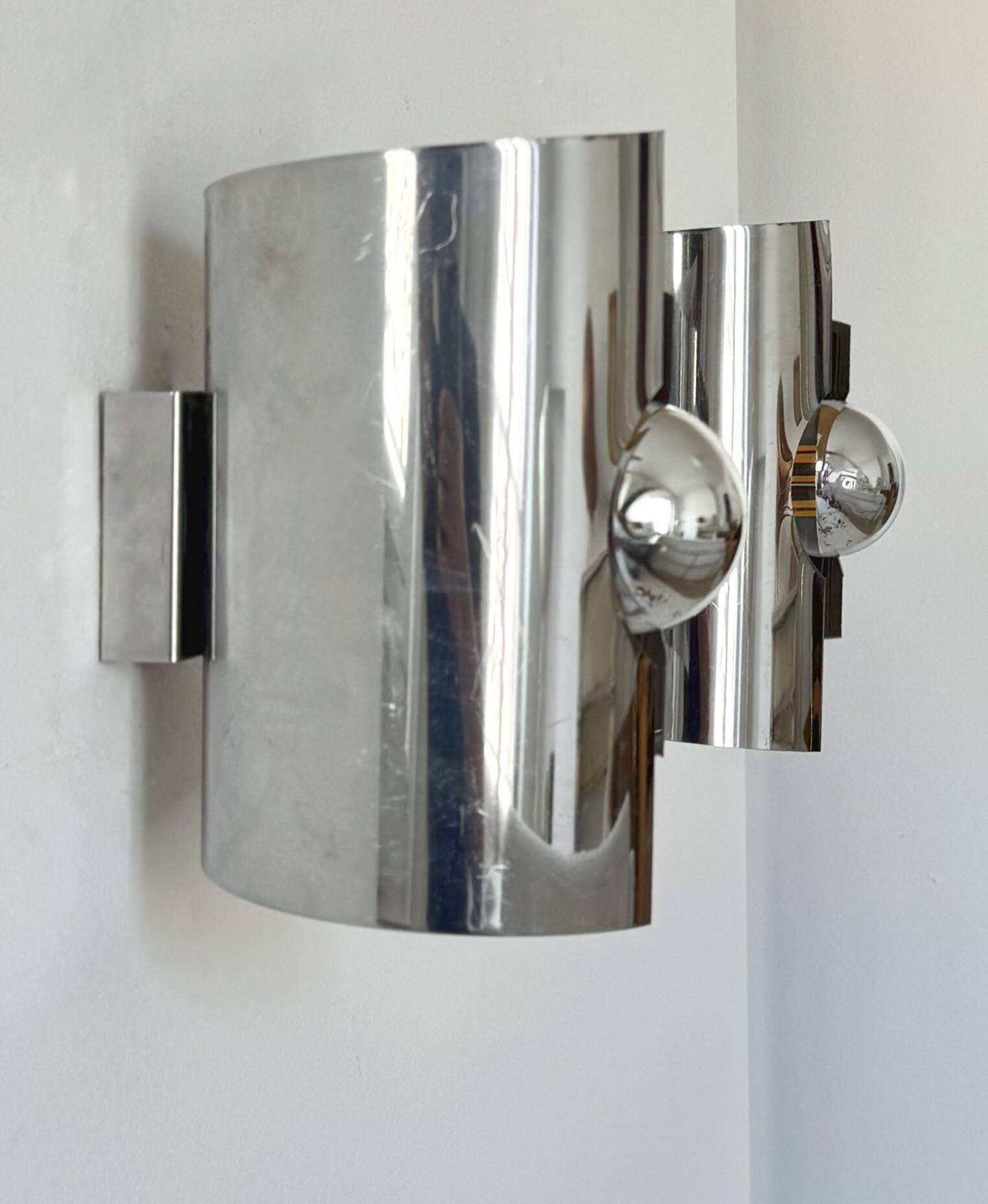 Pair of vintage wall lights, curved chrome metal, France, 1970.