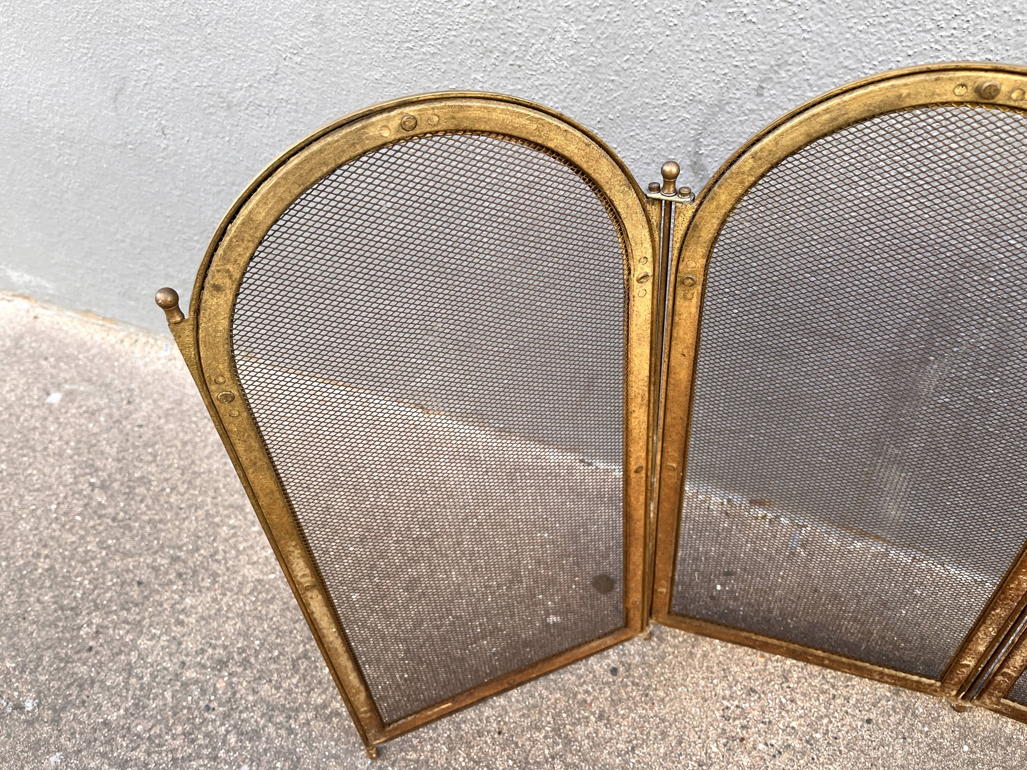 Antique brass fireplace screen from 1920, vintage spark guard.