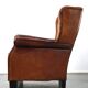 Very large worn sheepskin wing chair with a checked seat cushion
