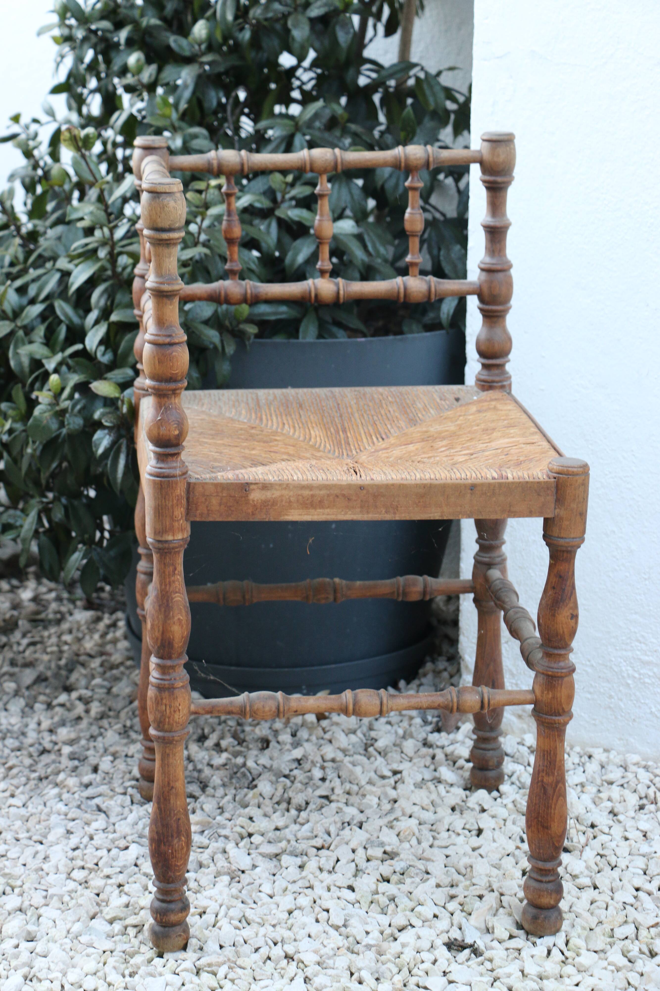 Antique corner chair in wood bamboo style seated in straw