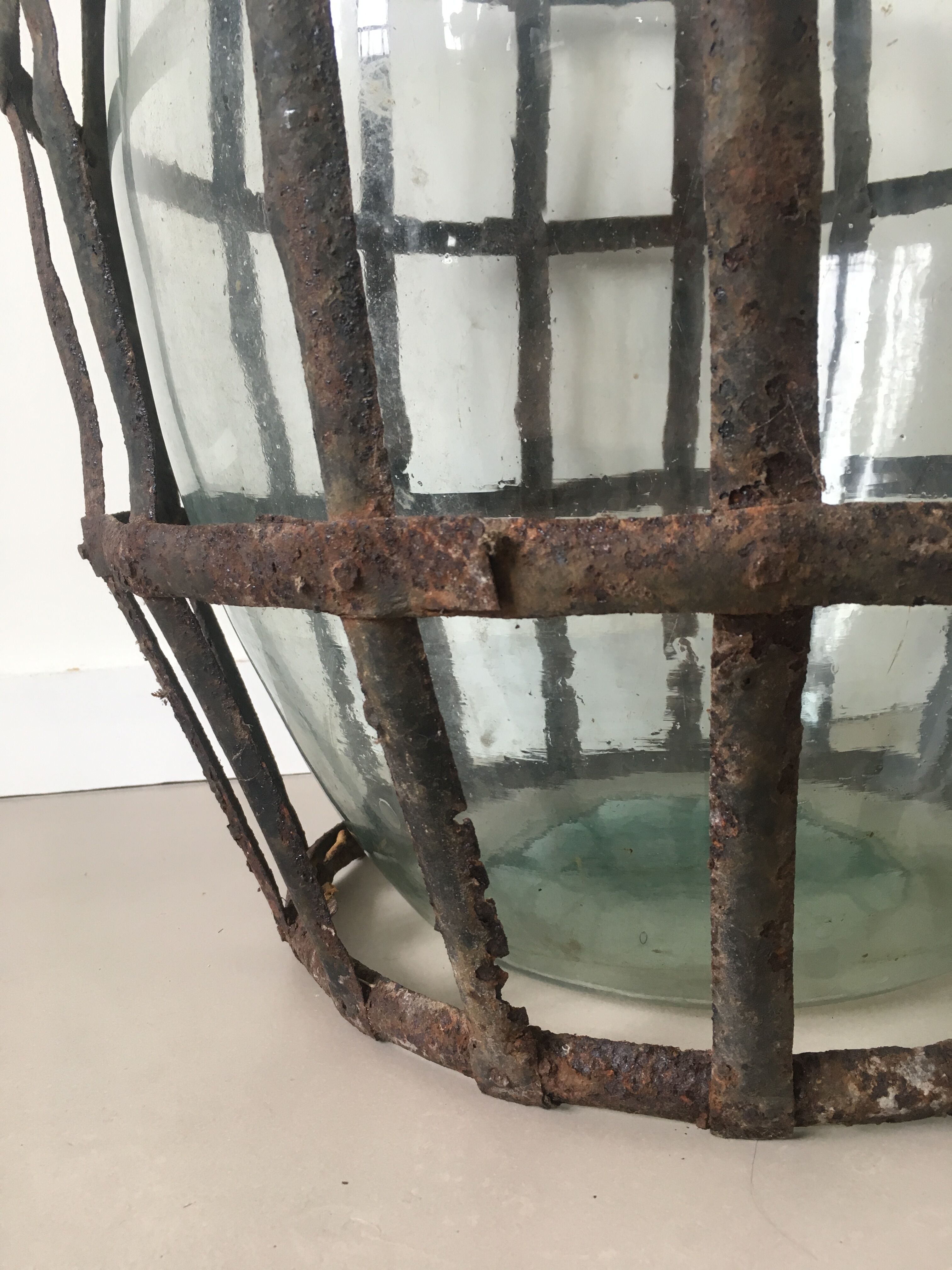 Old demijohn and her metal basket