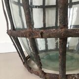 Old demijohn and her metal basket