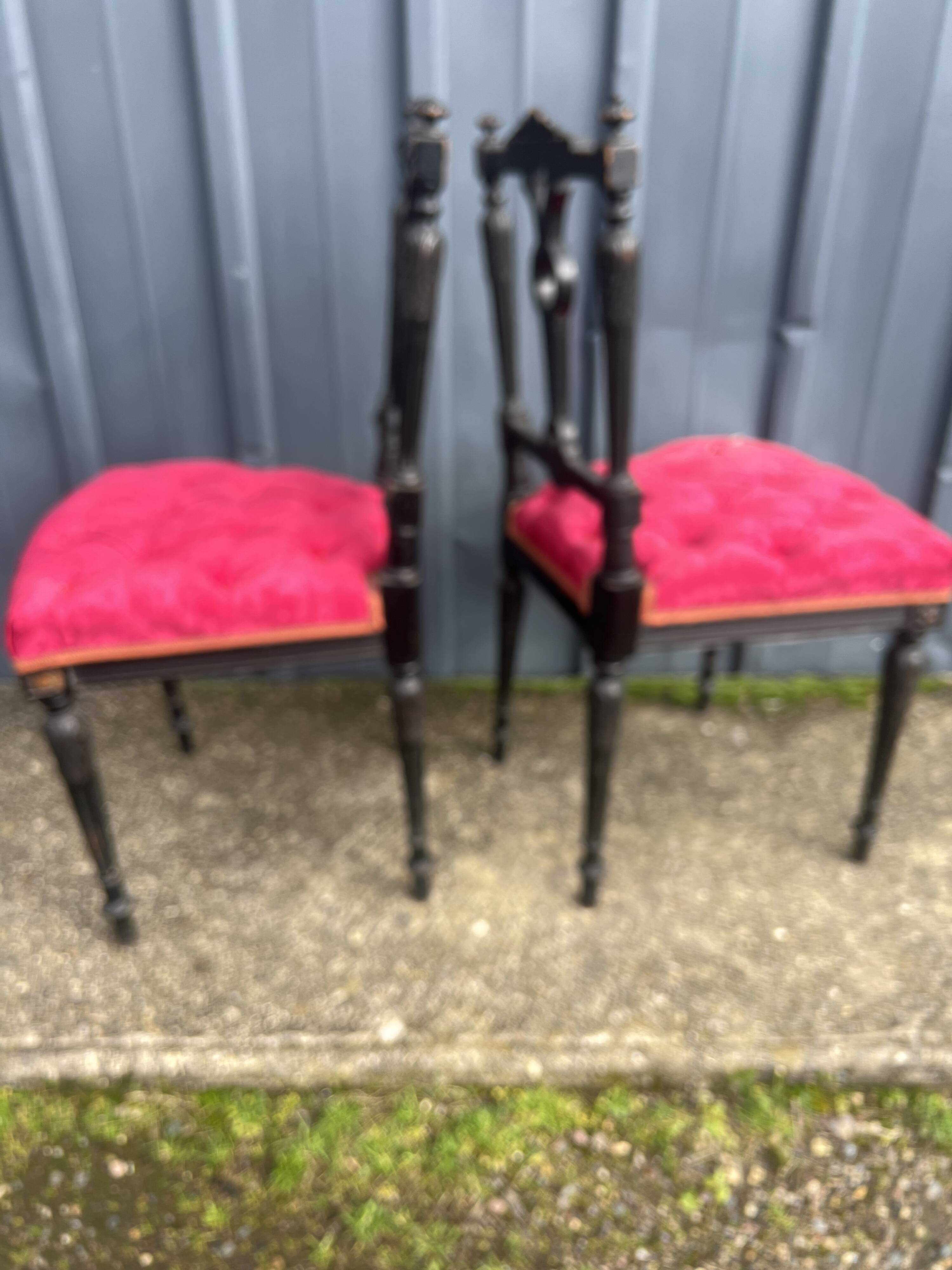 Pair of black lacquered chairs with purple tufted upholstery.