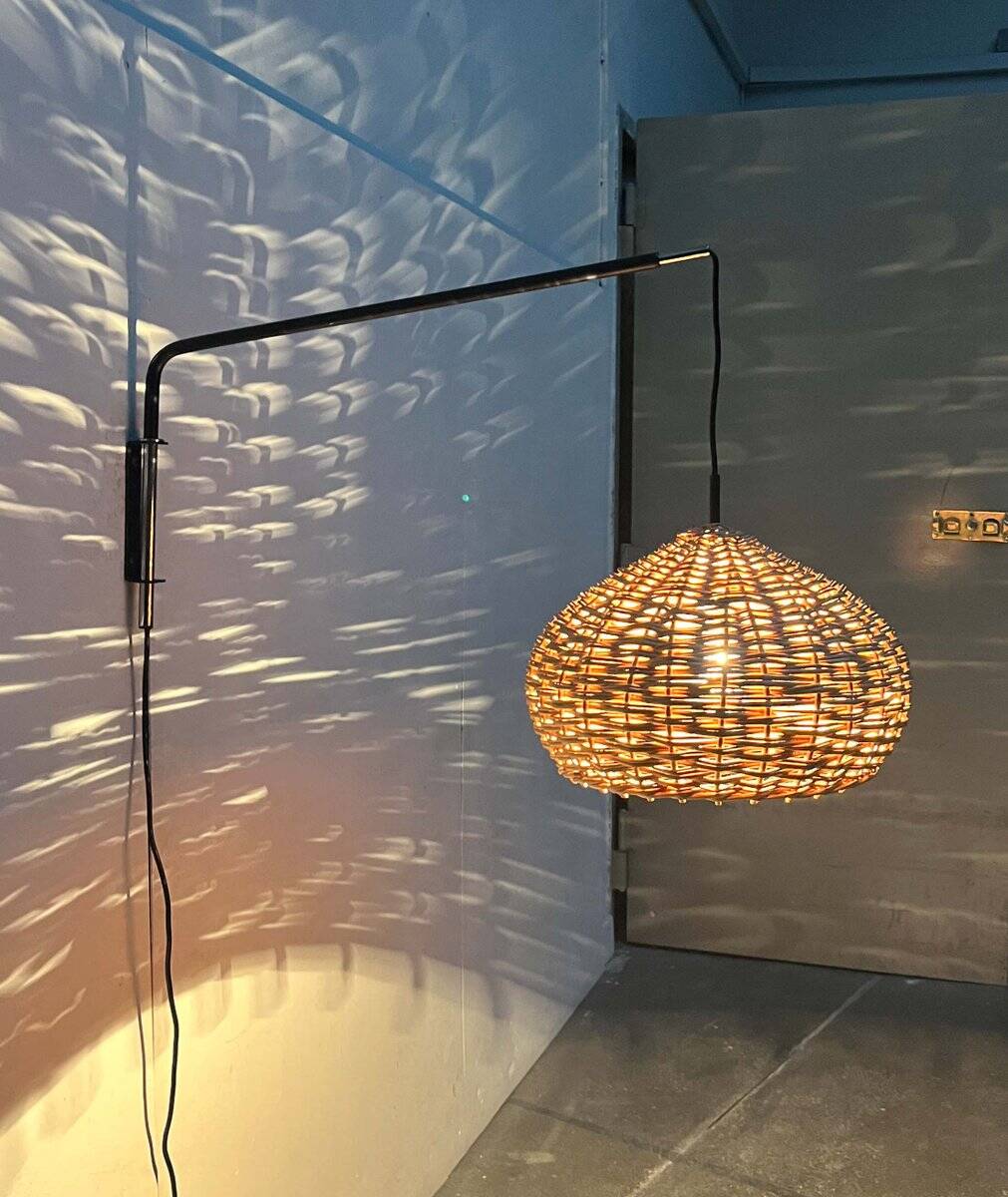 Mid-century modern Danish extendable cantilever wall lamp with a rattan shade, 1960s.