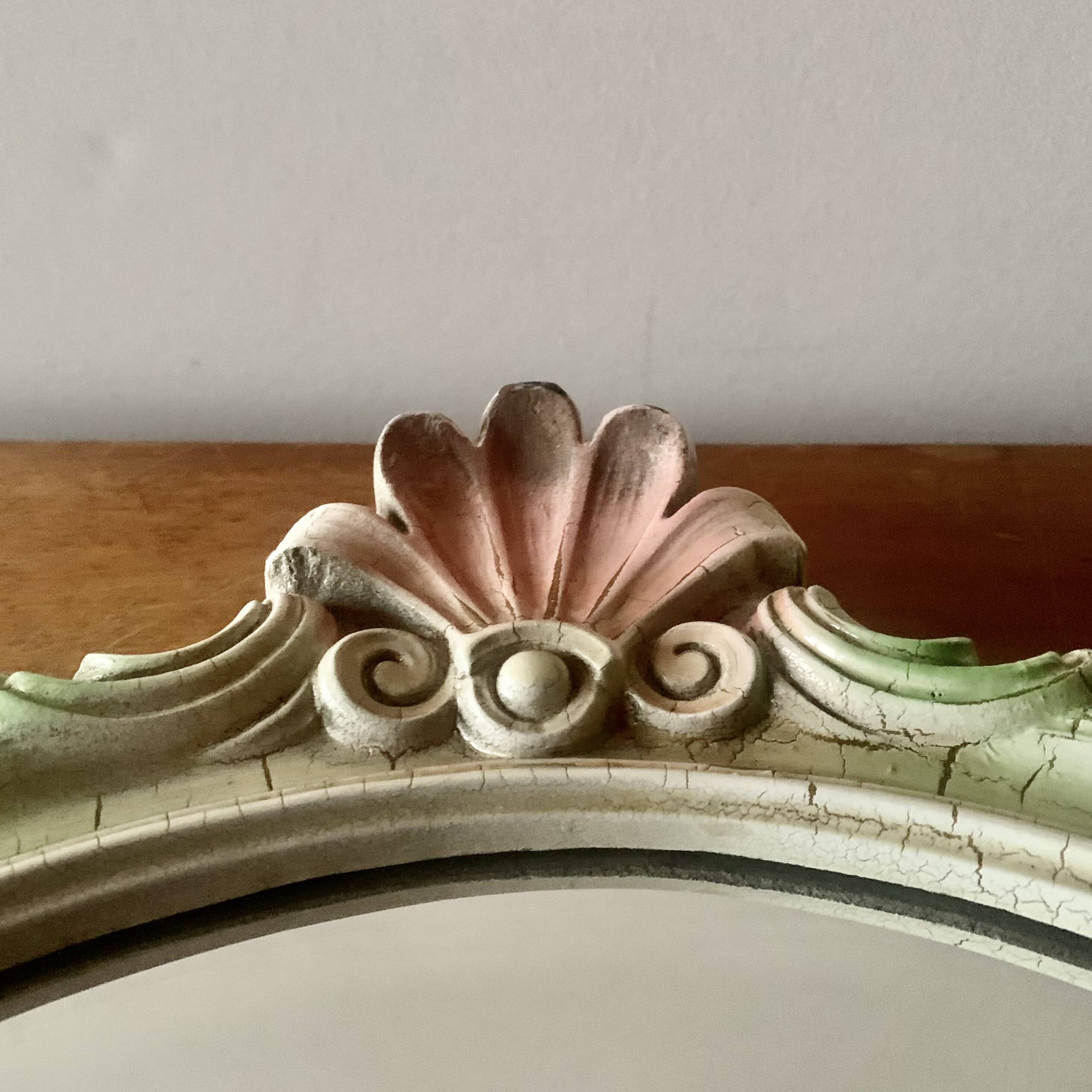 Vintage oval mirror in carved wood in pastel tones