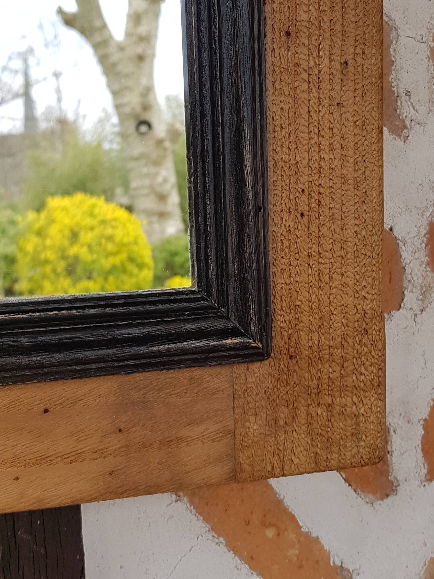 Black mirror and raw natural wood