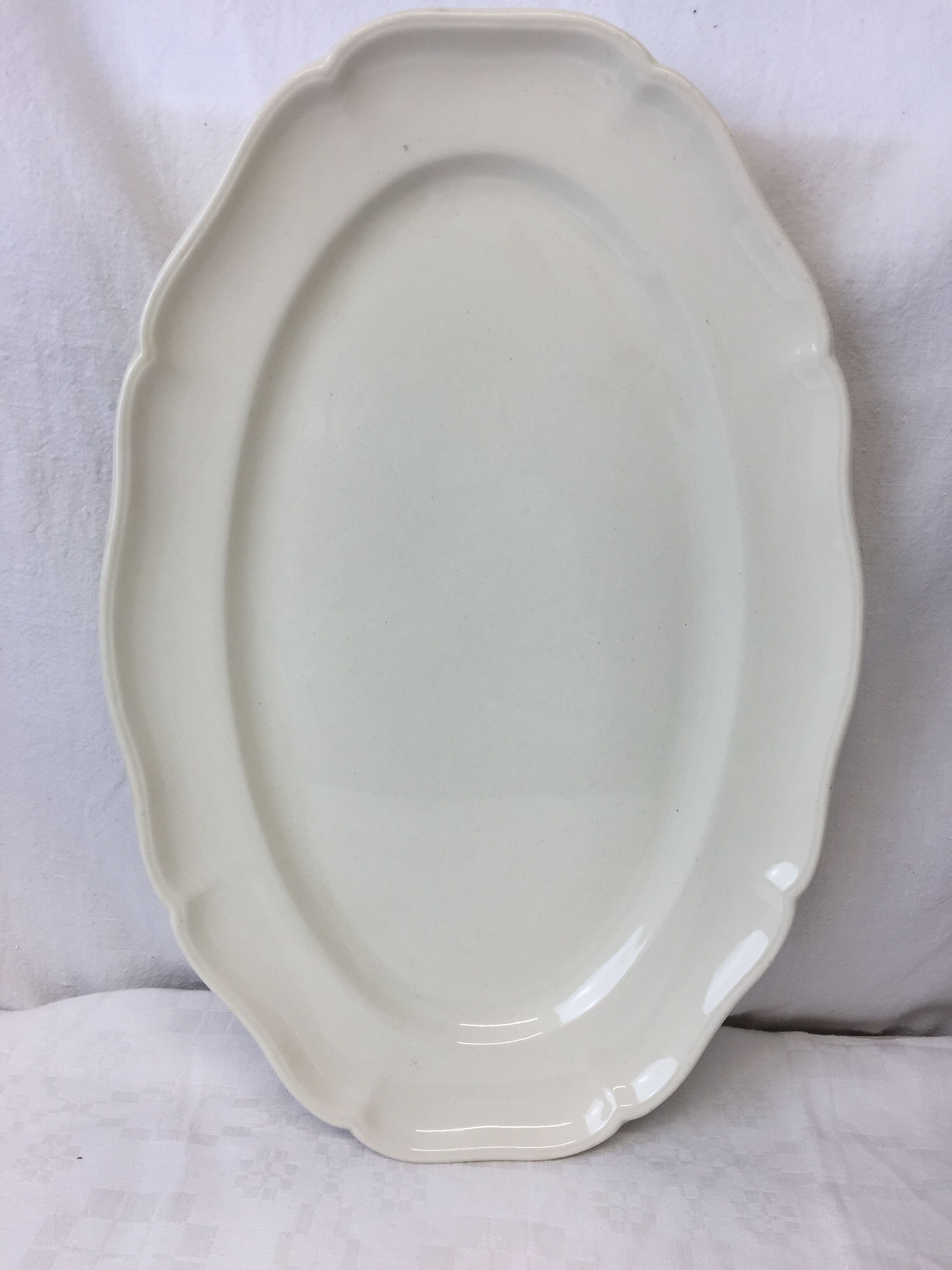 Old ivory-colored, oval-shaped dish with chamfered edge