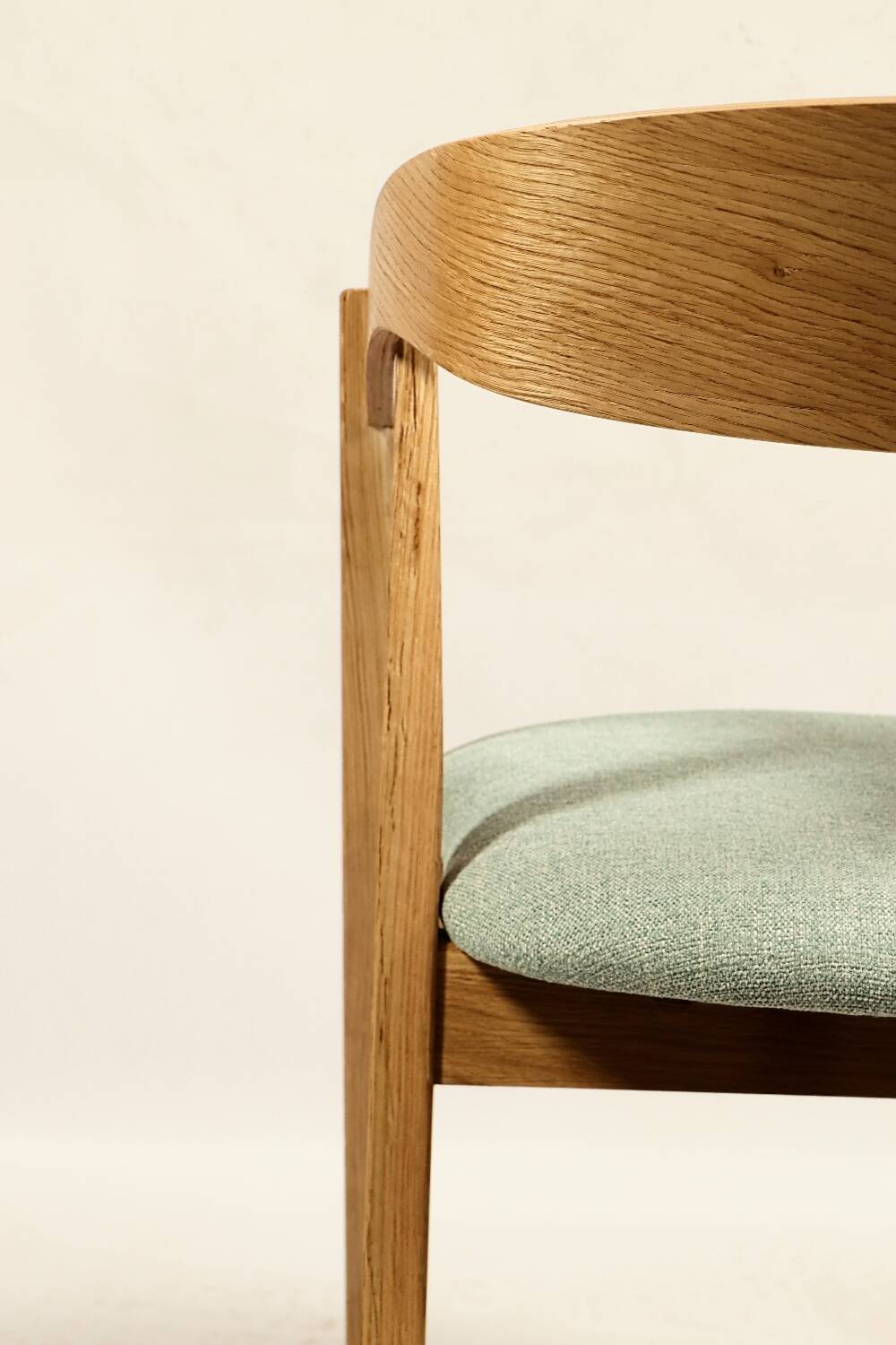Vintage dining chair in light oak with natural linen pastel green fabric.
