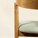 Vintage dining chair in light oak with natural linen pastel green fabric.