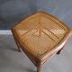 Antique wooden stool with cane seat.