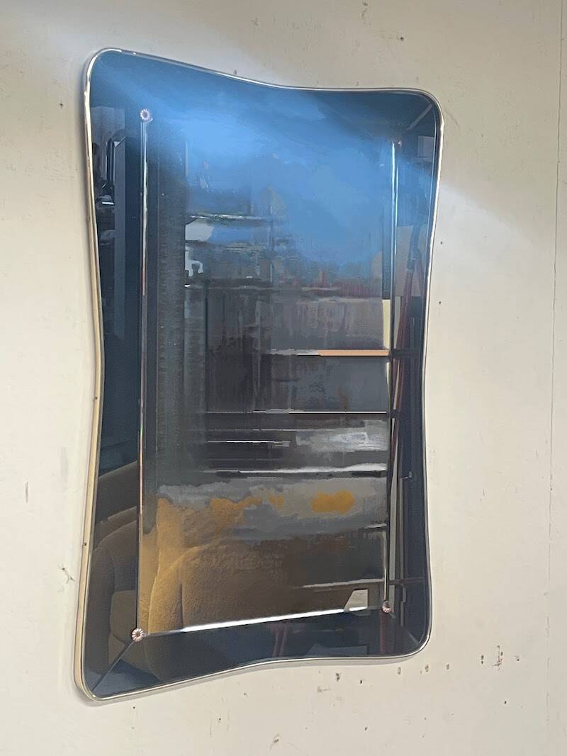 1950s double-thickness wall mirror with brass profile and supports.