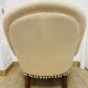 Pale pink upholstered armchair with wooden legs.