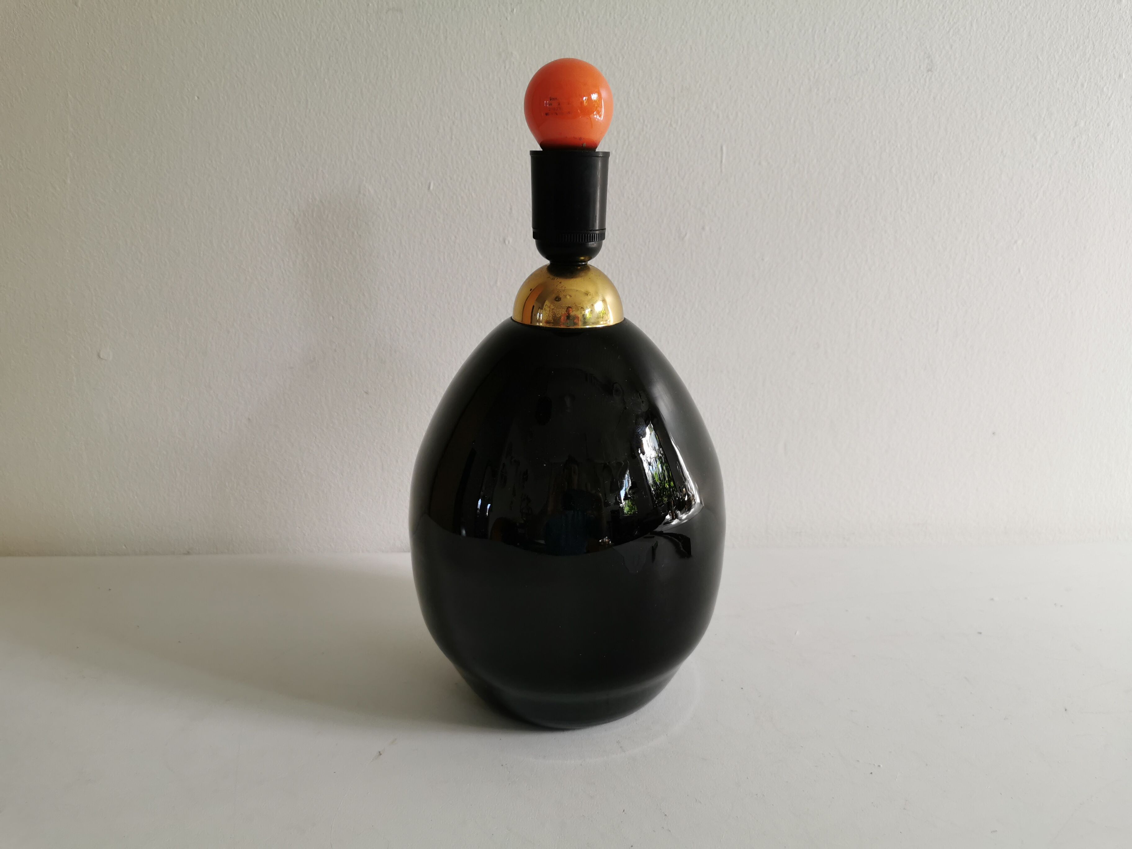 Table lamp, made of handmade coal-black glass, with brass coloured top.