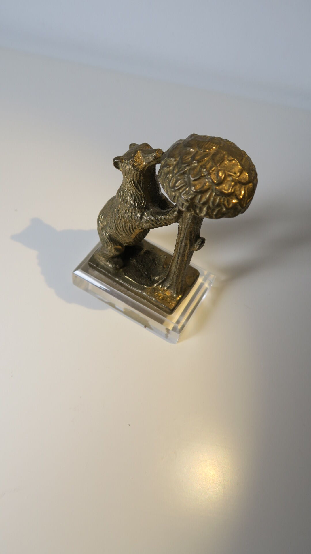 Brass sculpture, bear looking for honey in the tree