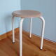 Industrial tubular metal stick sitting round in wood