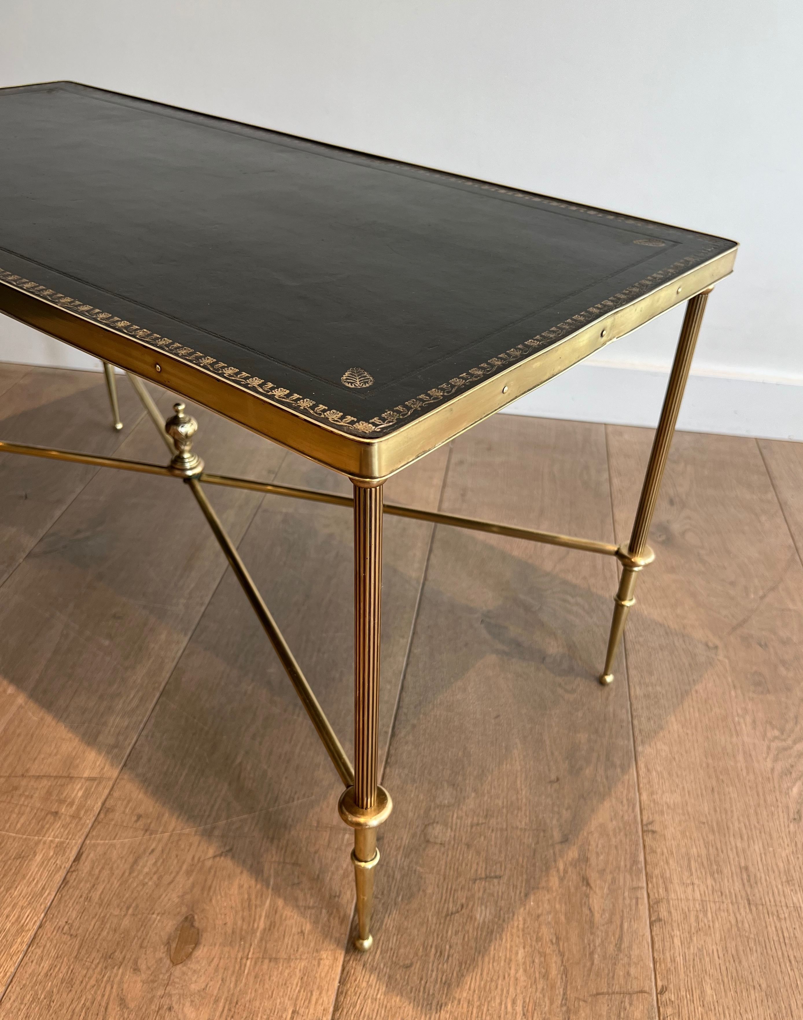 Neoclassical brass coffee table with a black leather top and golden borders from Maison Jansen.