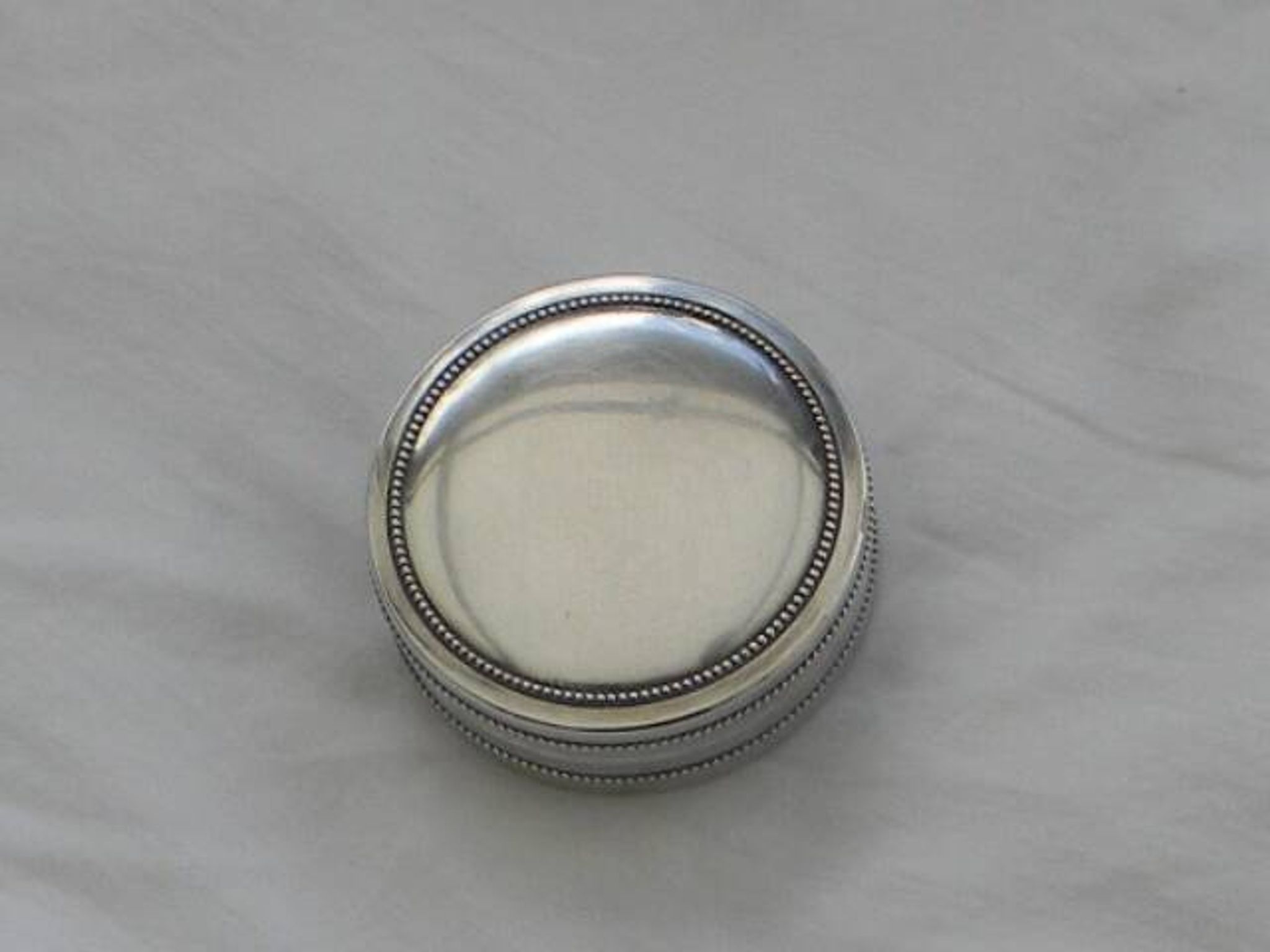Small round silver metal box SNPA.