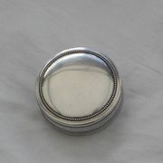 Small round silver metal box SNPA.