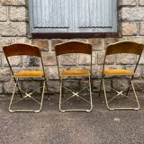 Three folding opera chairs in old gold velvet and brass structure