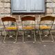 Three folding opera chairs in old gold velvet and brass structure
