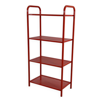 Red perforated metal shelving unit on legs, 1980.