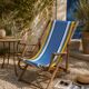 Vintage deck chair with blue and yellow striped fabric, original patina.
