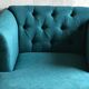 Mid-century turquoise blue fabric sofa with solid oak legs and tufting.