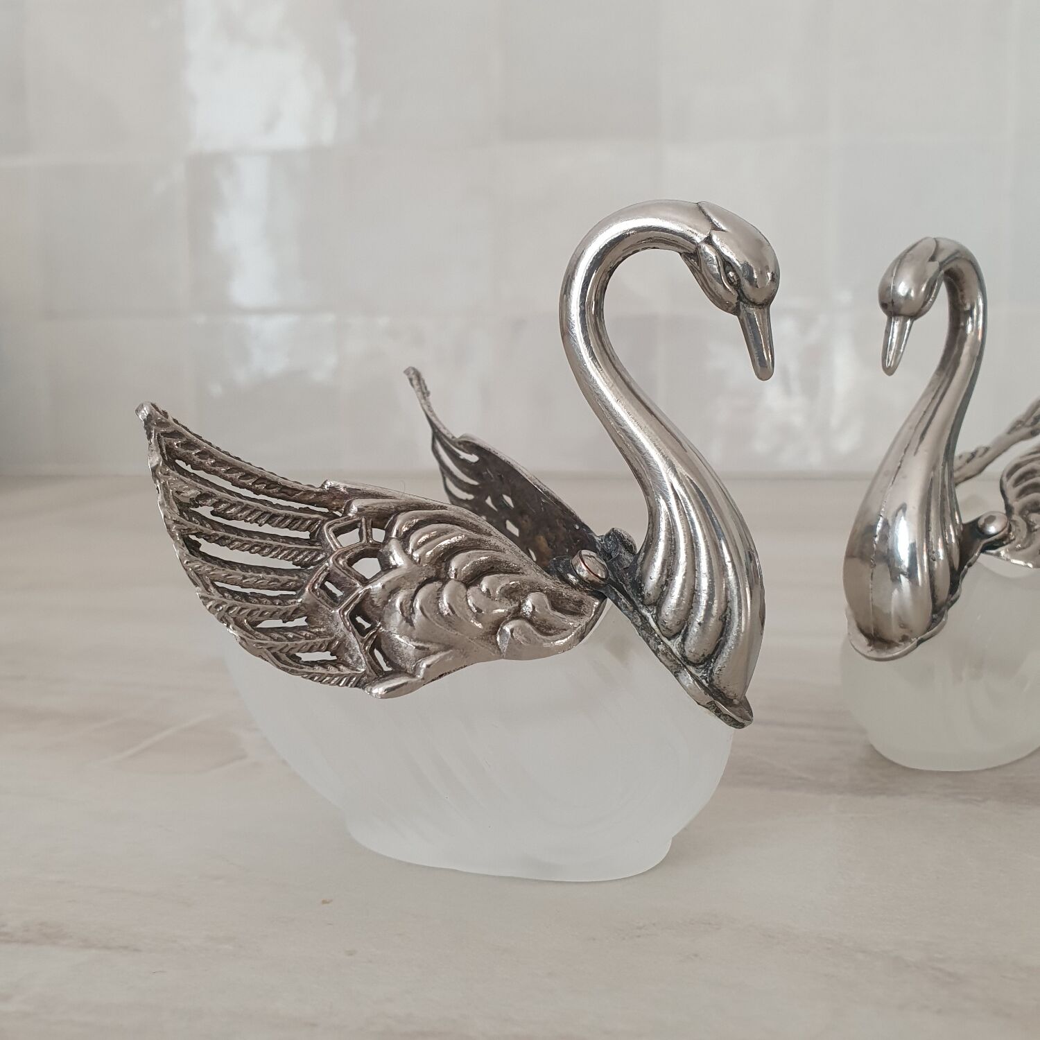 Two frosted glass swan salt cellars with silver plating.