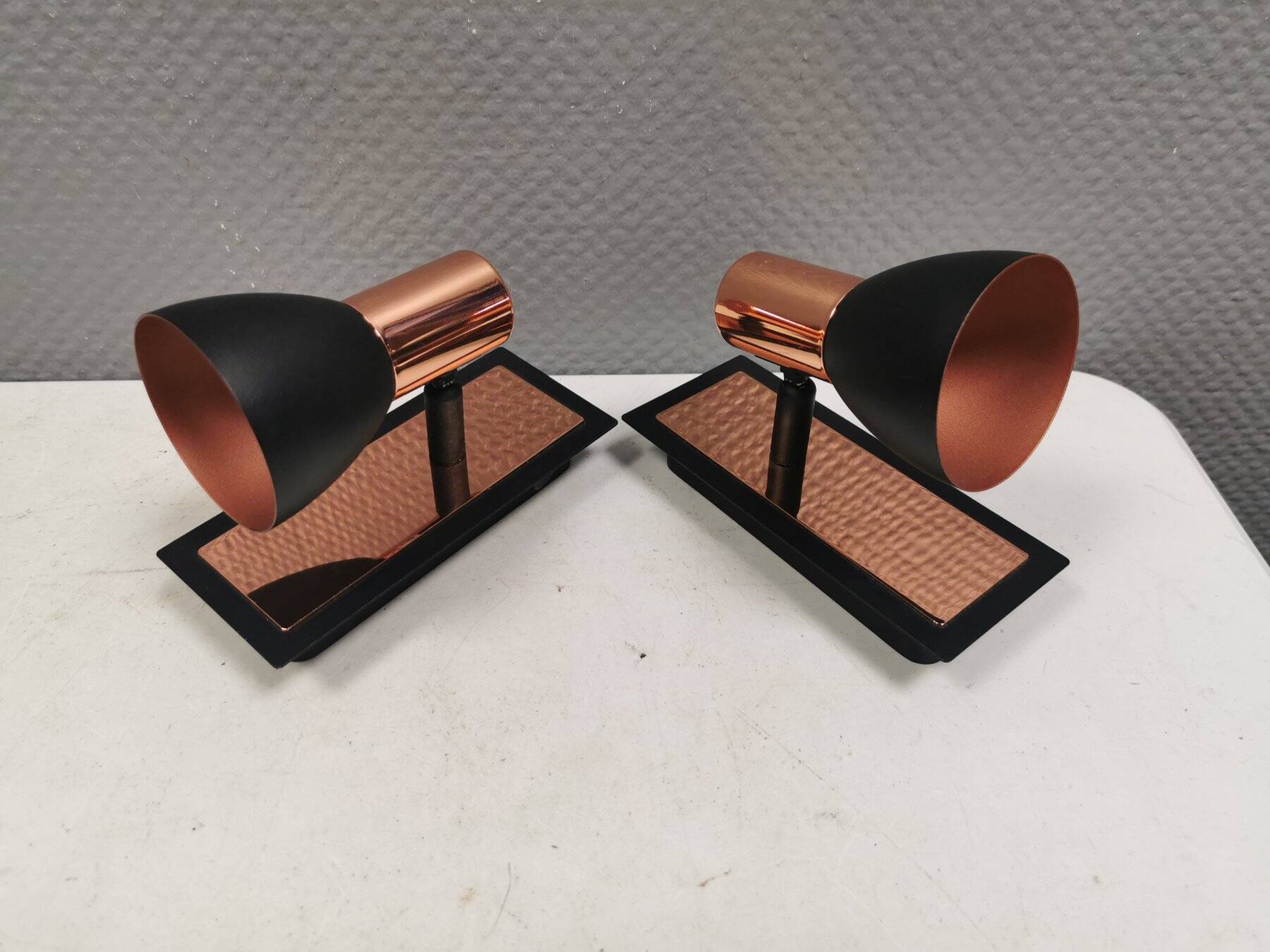 A pair of wall lamps from Eglo, in copper color and black.
