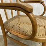 Curved wood and cane armchair