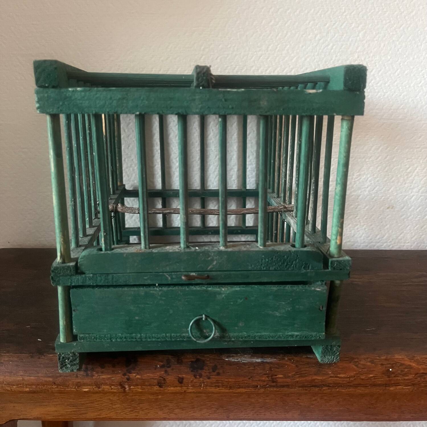 old bird cage made of wood and painted green