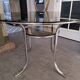 Round table in chromed metal and smoked glass