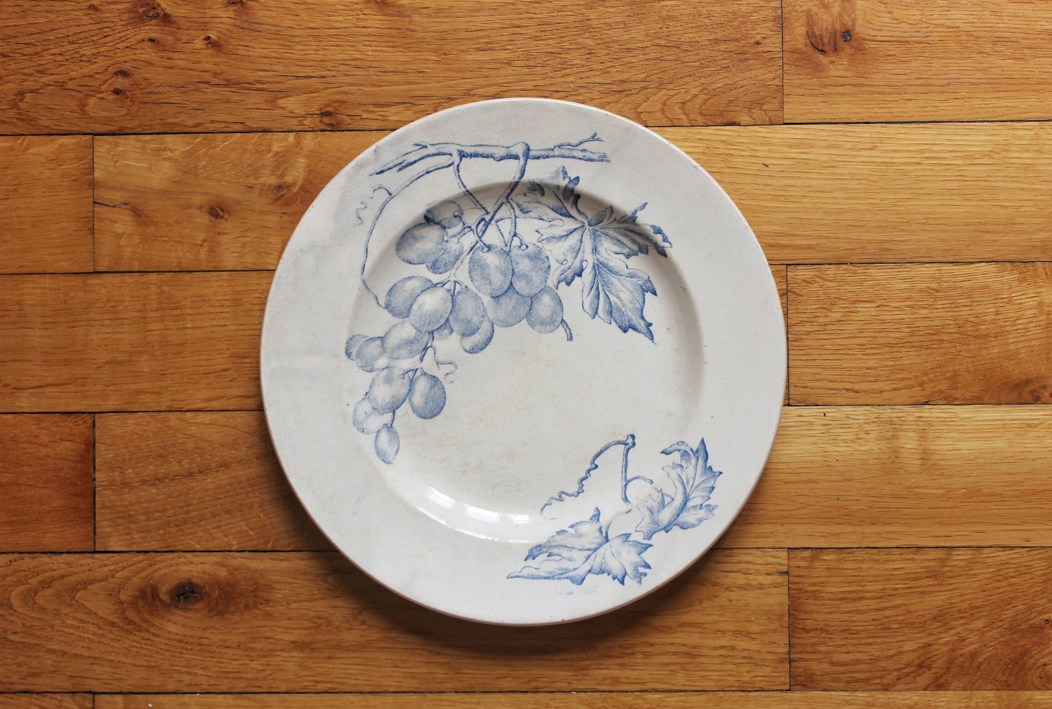 Plat rond en terre de fer décor de vignes et raisins, fin XIXe début XXe
