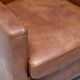 Pair of Art Deco armchairs in brown leather and teak, Netherlands, 1970s.