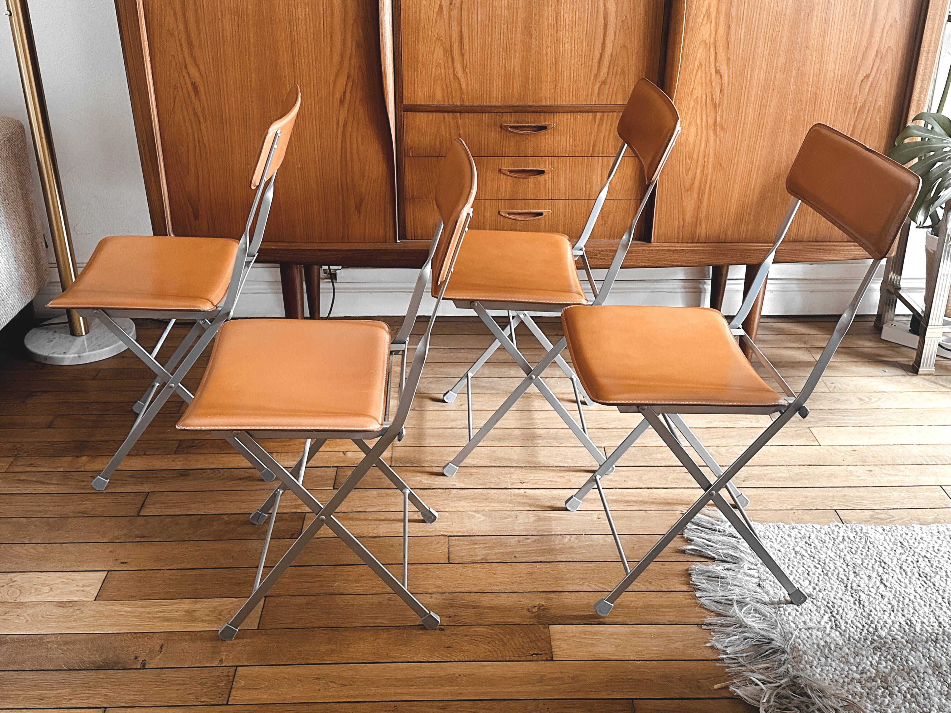 4 folding Sintesi chairs for DWR Lina in metal and vintage camel leather.